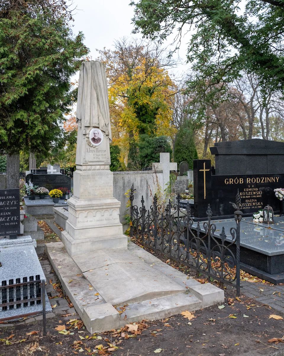 Jasny obelisk nagrobny z kutym ogrodzeniem